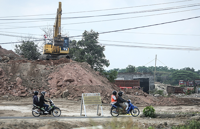 TERLENDALA: Warga melintas diantara pengerjaan jalan tol jogja-solo di kawasan Tirtomartani, Kalasan, Sleman (14/8).