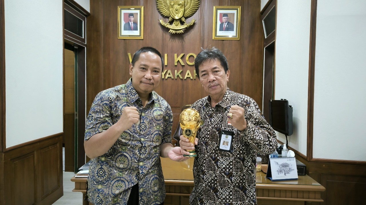 Pj Wali Kota Yogyakarta Sugeng Purwanto (kanan) menunjukkan penghargaan Universal Health Coverage (UHC) Awards Tahun 2024, Rabu (14/8/2024).