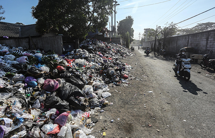 Warga melintas disamping tumpukan sampah yang dibuang di depo lama kawasan Wiyoro, Banguntapan, Bantul, Kamis (15/8).