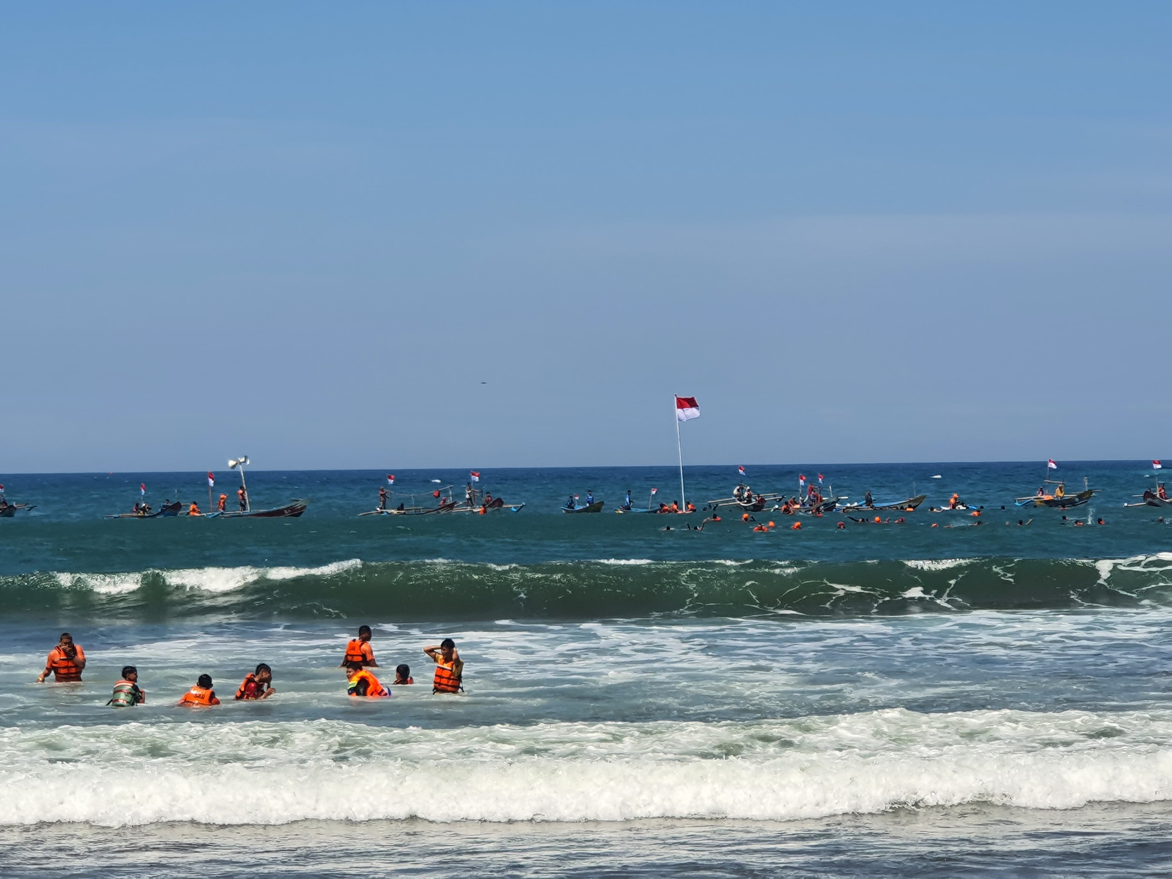 Pengibaran Bendera Merah Putih dalam rangka Upacara HUT Ke-79 RI di perairan Samudera Hindia tepatnya di Pantai Baron, Kalurahan Kemadang, Kapanewon Tanjungsari, Gunungkidul, Sabtu (17/8/2024).