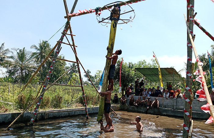 SERU: Warga Randusari, Argomulyo, Cangkringan saat mengikuti lomba panjat pohon pisang dan memperebutkan berbagai hadiah (18/8).Delima Purnamasari/Radar Jogja