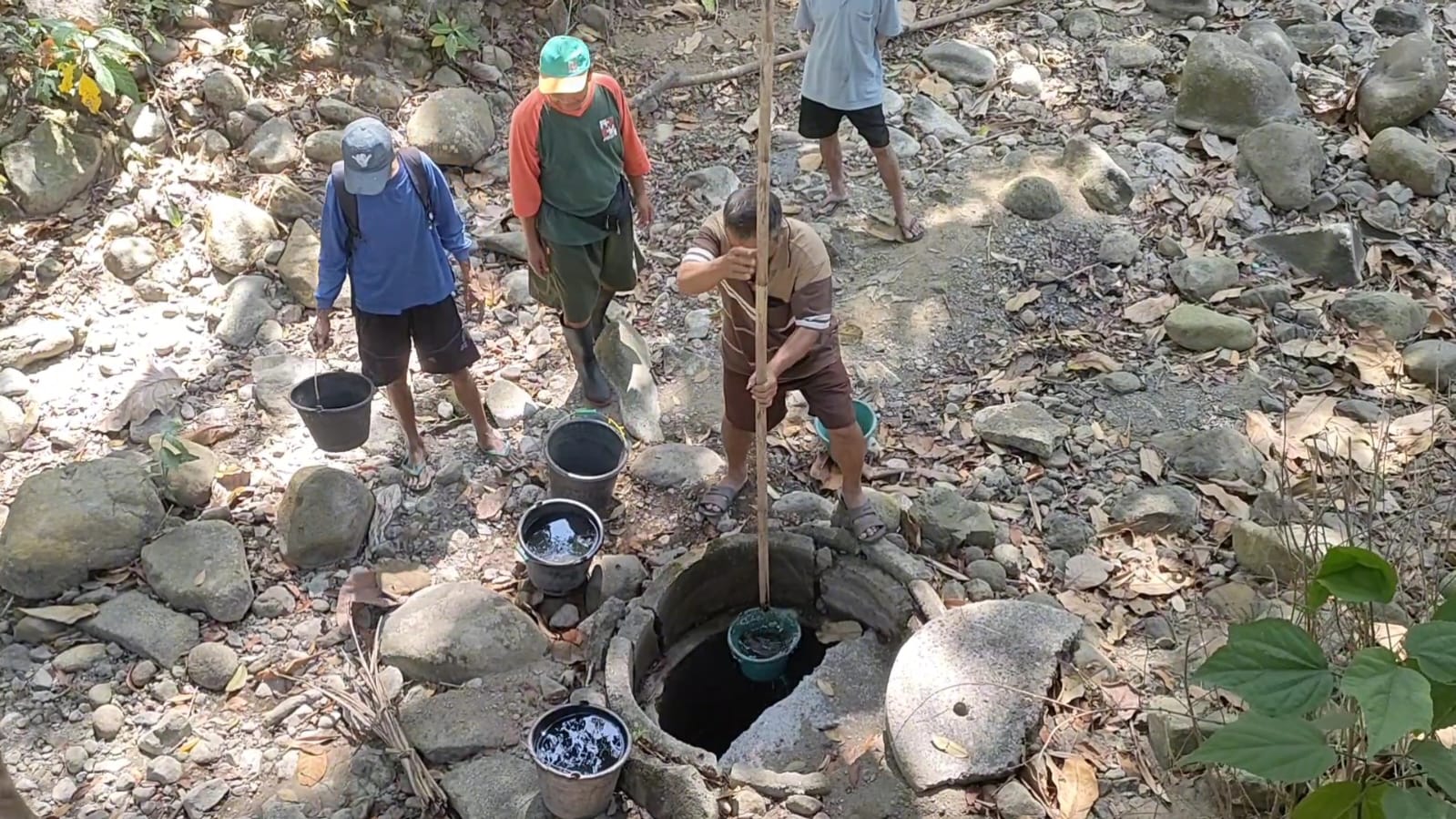 MENGGALI: Warga Tangkisan 2 mencari air dengan menggali sumur di sungai kering.