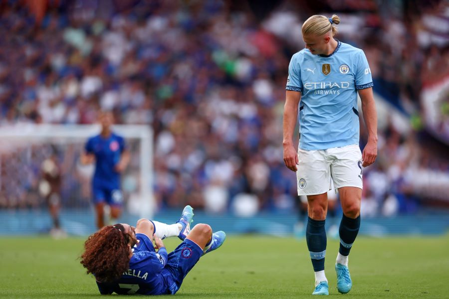 Erling Haaland hanya melewati dan tersenyum kepada Marc Cucurella yang kram. (rex)