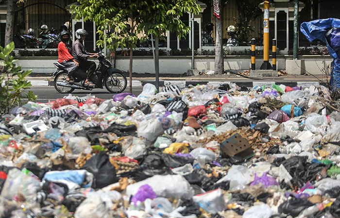 Pengendara motor melintasi tumpukan sampah yang dibuang di kawasan lahan revitalisasi PasarTerban, Jogja, Rabu (21/8).