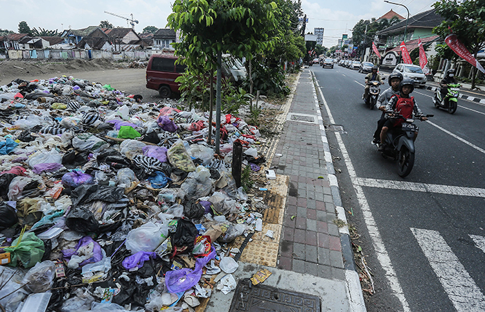 Pengendara motor melintasi tumpukan sampah yang dibuang di kawasan lahan revitalisasi PasarTerban, Jogja, Rabu (21/8).