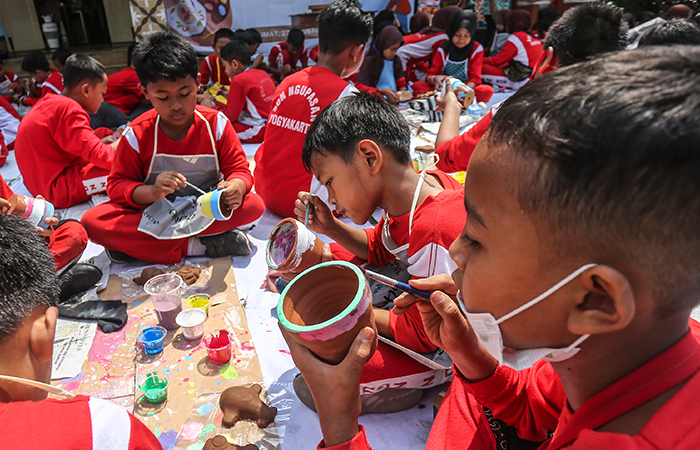 Siswa-siswi kelas 1-3 bersama-sama menghias pot tanaman dari gerabah di sekolah SDN Ngupasan, Jogja, Jumat (23/8).
