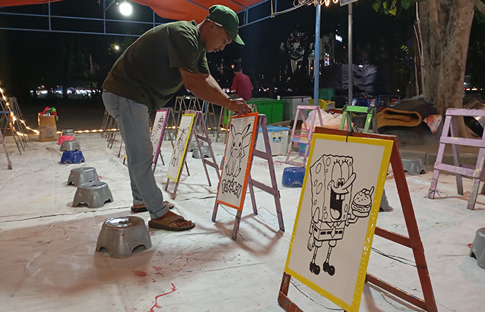 LARIS MANIS: Penyedia jasa lukis styrofoam di Lapangan Denggung saat tengah menata stand-stand melukis pada Kamis (23/8) malam. Diminati kalangan mahasiswa, omzet capai ratusan ribu rupiah per hari.