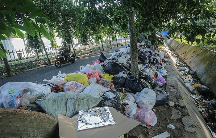 Ilustrasi Sampah Liar Pengendara motor melintasi tumpukan sampah liar di jalan Kusbini, Demangan, Jogja.