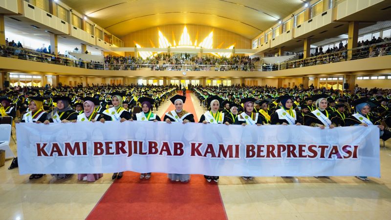 TERBAIK: Wisudawati terbaik membentangkan spanduk dalam wisuda vokasi, sarjana, dan pascasarjana tahun akademik di Gedung Sportorium UMY pada Rabu (4/9/2024).