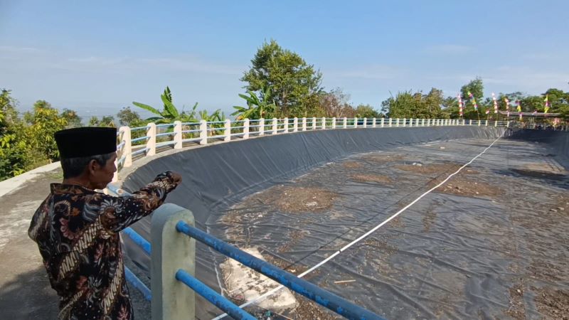 MENUNJUK: Samadi menunjukkan embung yang rusak dan tak kunjung diperbaiki.