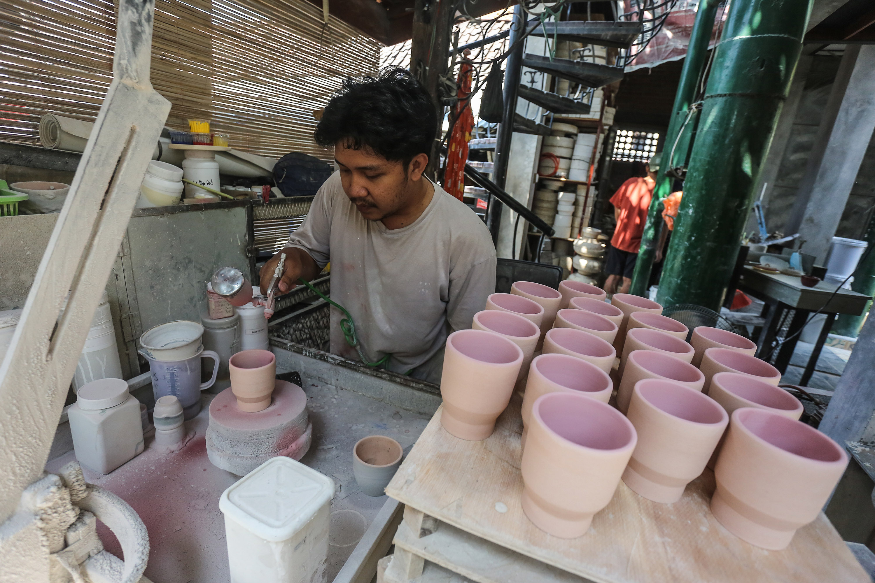 Pengrajin melakukan pewarnaan gelas berbahan tanah liat sebelum proses pemanggangan di rumah produksi kerajinan keramik di kawasan Teggalpanggung, Danurejan, Jogja, Jumat (30/8). Sektor usaha Industri Kecil Menengah (IKM) di wilayah DIJ mempu berkontribus