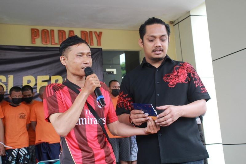 Kasat Reskrim Polresta Sleman AKP Riski Adrian (kanan) saat menyerahkan barang bukti handphone kepada korban Sumadi (kiri) dalam proses pinjam pakai barang bukti di Mapolda DIY, Selasa (10/9/2024).