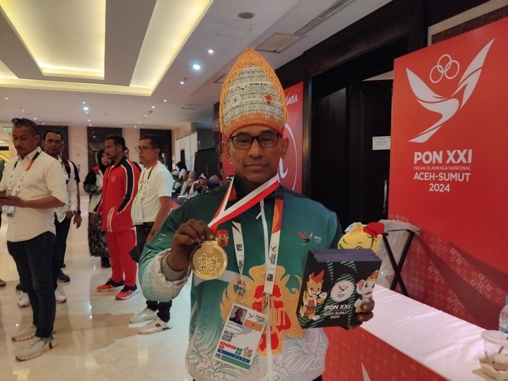 Bambang Sujatmoko memamerkan medali emas yang diraihnya.