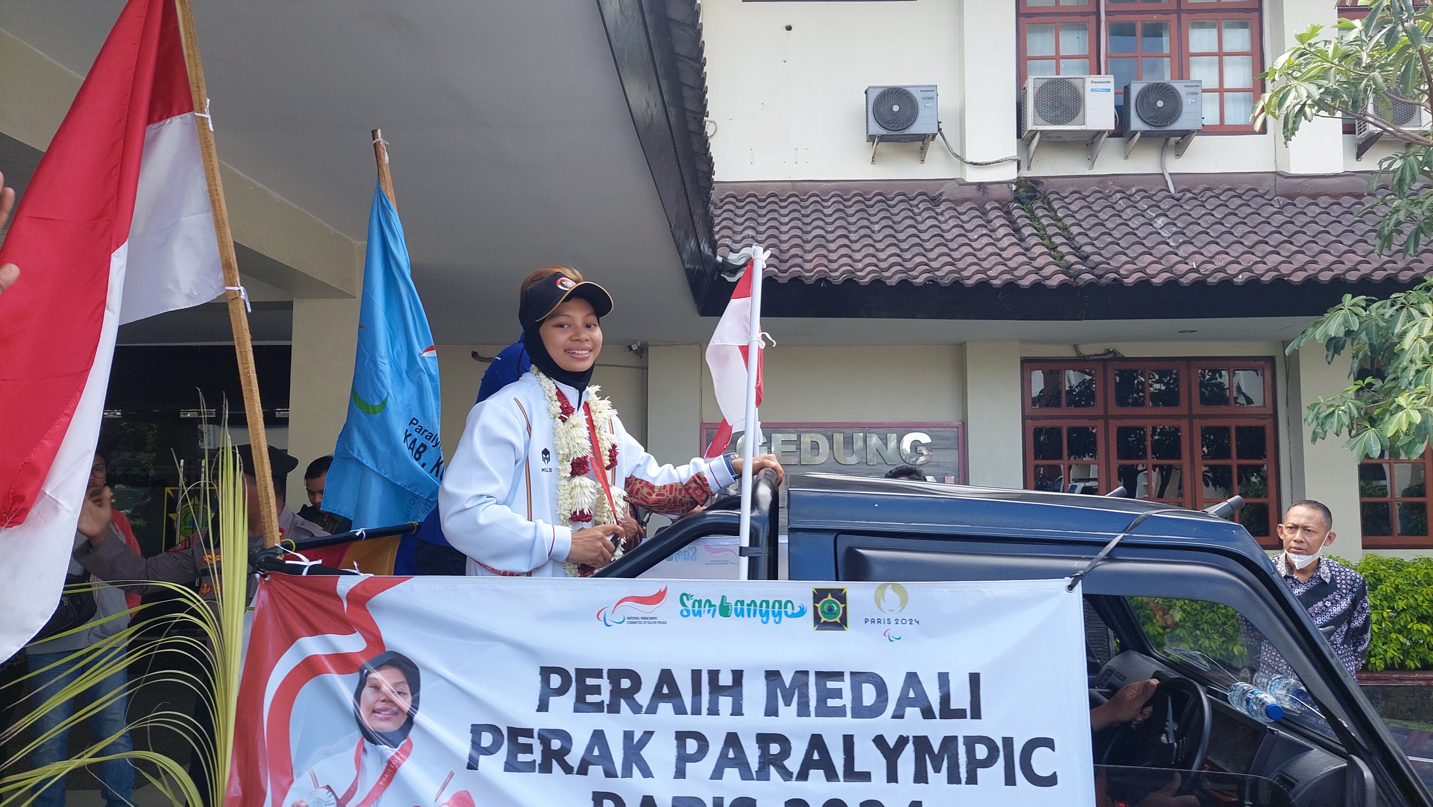 KIRAB: Qonitah menunjukkan medali peraknya sambil diarak menuju halaman Pemkab.