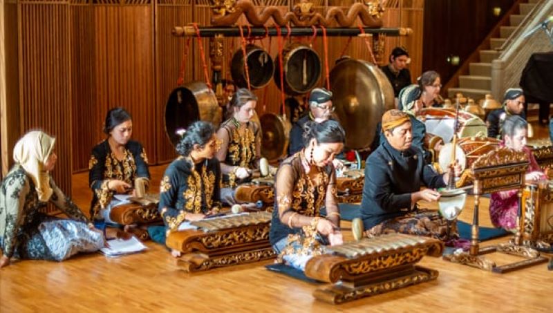 Menabuh gamelan.