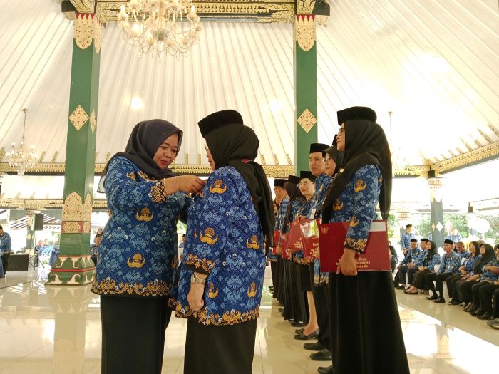SIMBOLIS: Bupati Sleman Kustini Sri Purnomo saat memberikan tanda kehormatan Satyalancana Karya Satya kepada 154 PNS Selasa (17/9/2024).