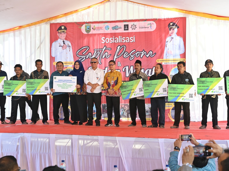 Bupati Kebumen Arif Sugiyanto menyerahkan secara simbolis bantuan kepada penderes nira sebagai peserta BPJS Ketenagakerjaan.