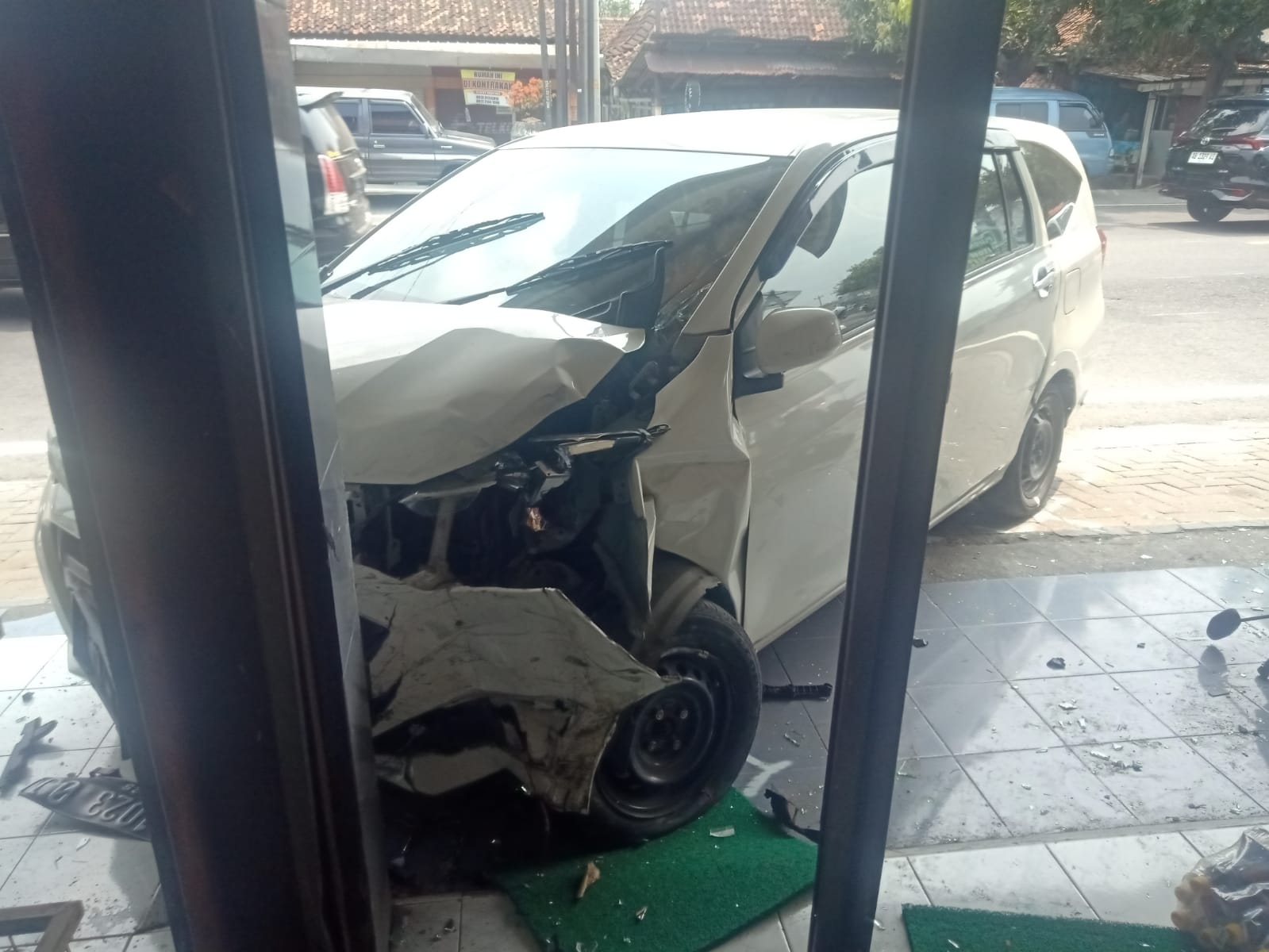 MENABRAK: Mobil menabrak bagian depan toko oleh-oleh.