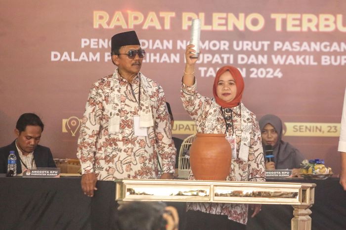 Pasangan Kustini Sri Purnomo-Sukamto menunjukan nomor undian untuk paslon Pilkada Sleman di KPU Sleman Senin (23/9/2024).