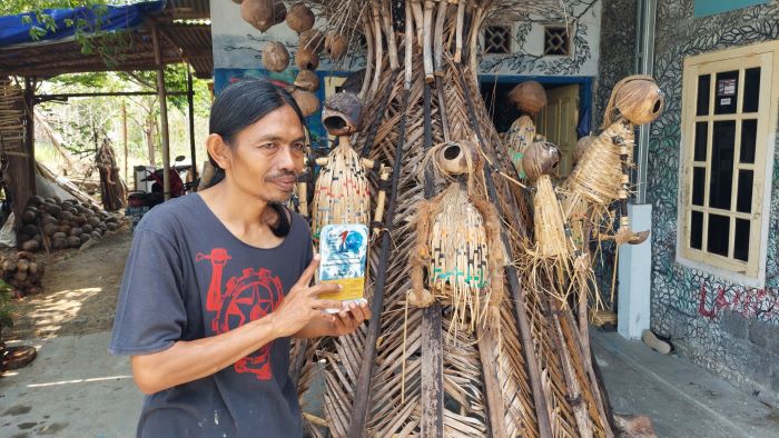 TANGGAPI ISU LINGKUNGAN: Teguh Paino memainkan Boneka Cumplung kreasinya dari sampah yang dipungutnya di Pantai Trisik.
