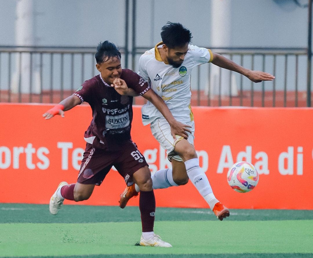 Pemain PSIM Jogja Saldi Amiruddin (putih) berebut bola dengan pemain Persipa Pati