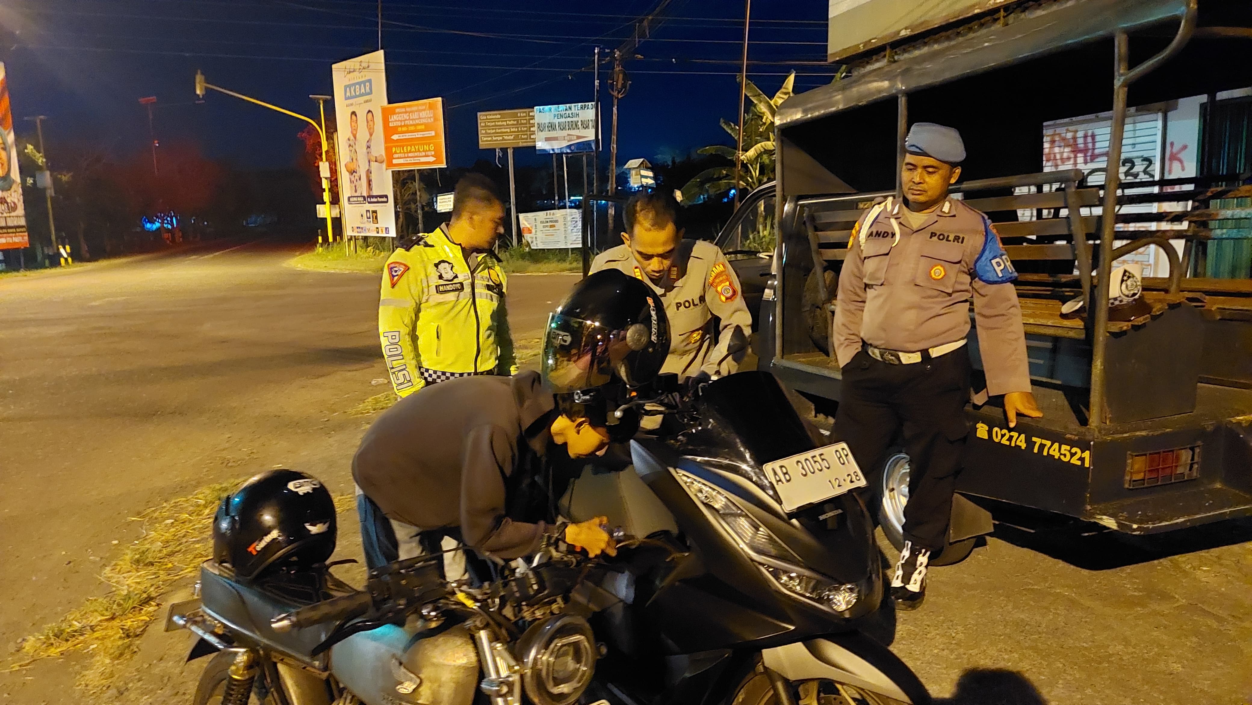MENGISI: Kapolsek Pengasih membantu pengendara mengisi bensin.