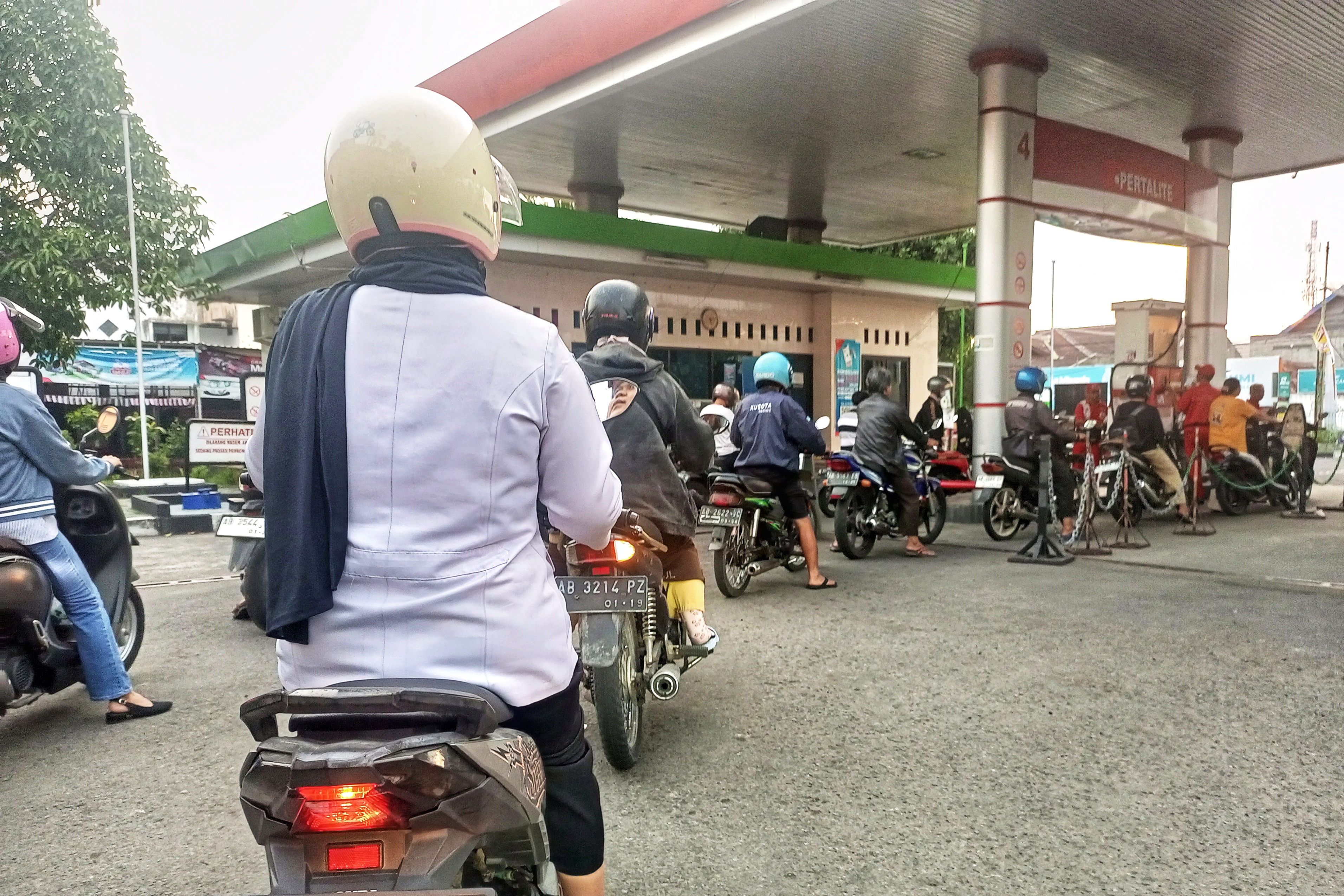 Pengendara sepeda motor antre saat membeli bahan bakar bensin di salah satu SPBU wilayah Kabupaten Sleman, Selasa  (10/1).