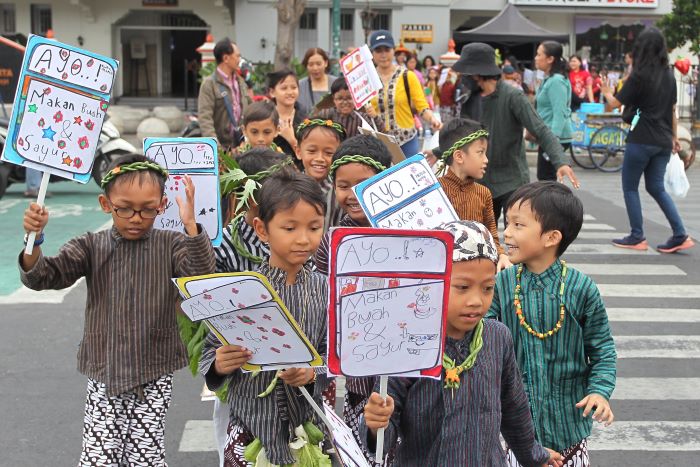KAMPANYE: Siswa SD Pangudi Luhur kelas II yang turun ke jalan membawa poster untuk mengajak masyarakat konsumsi sayur dan buah menuju Museum Sonobudoyo Rabu (2/10/2024).