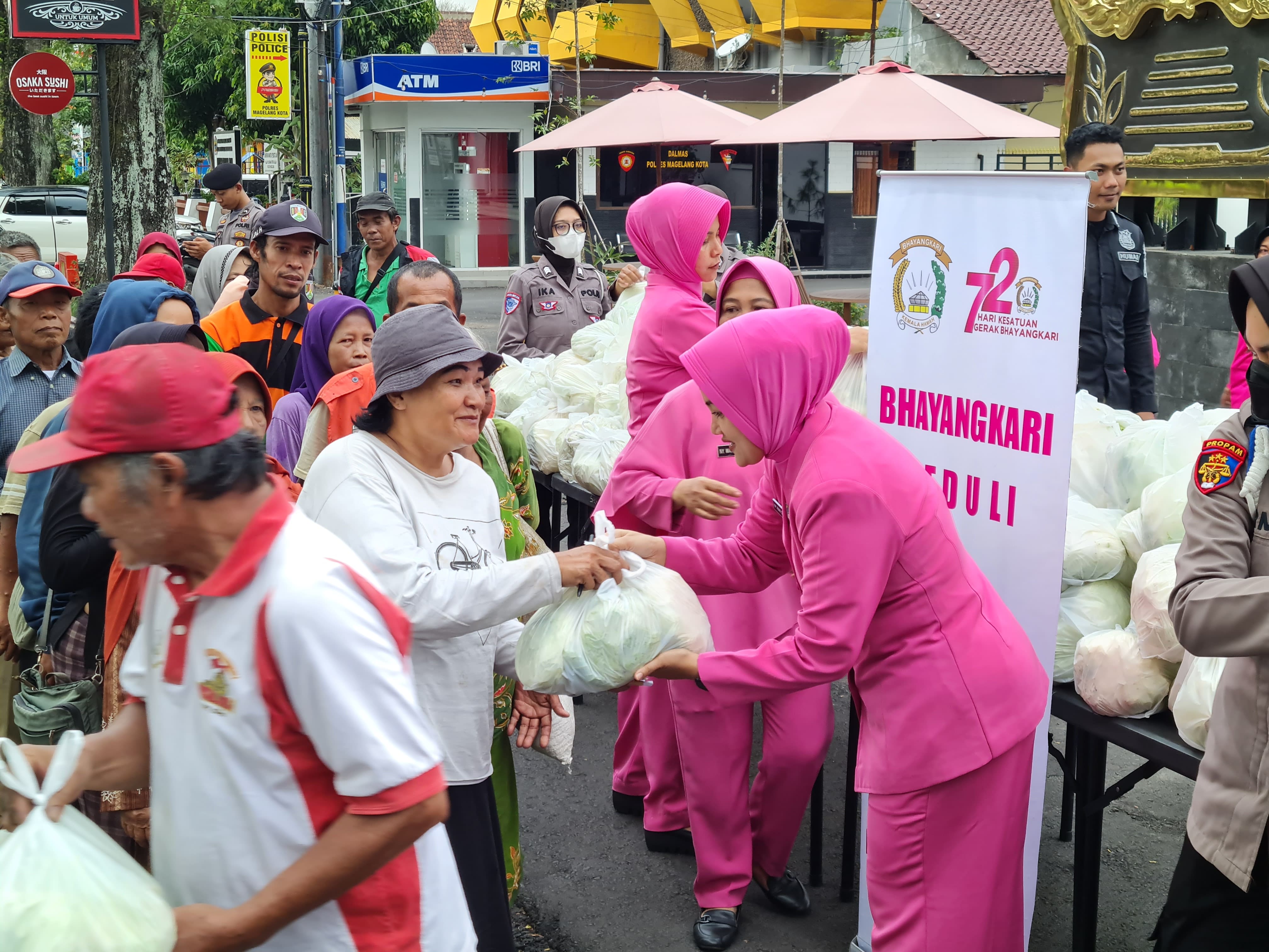 BANTU PETANI: Sejumlah personel polisi dan Bhayangkari Cabang Magelang Kota membagikan ratusan paket kubis, Kamis (3/10).  &nbsp;