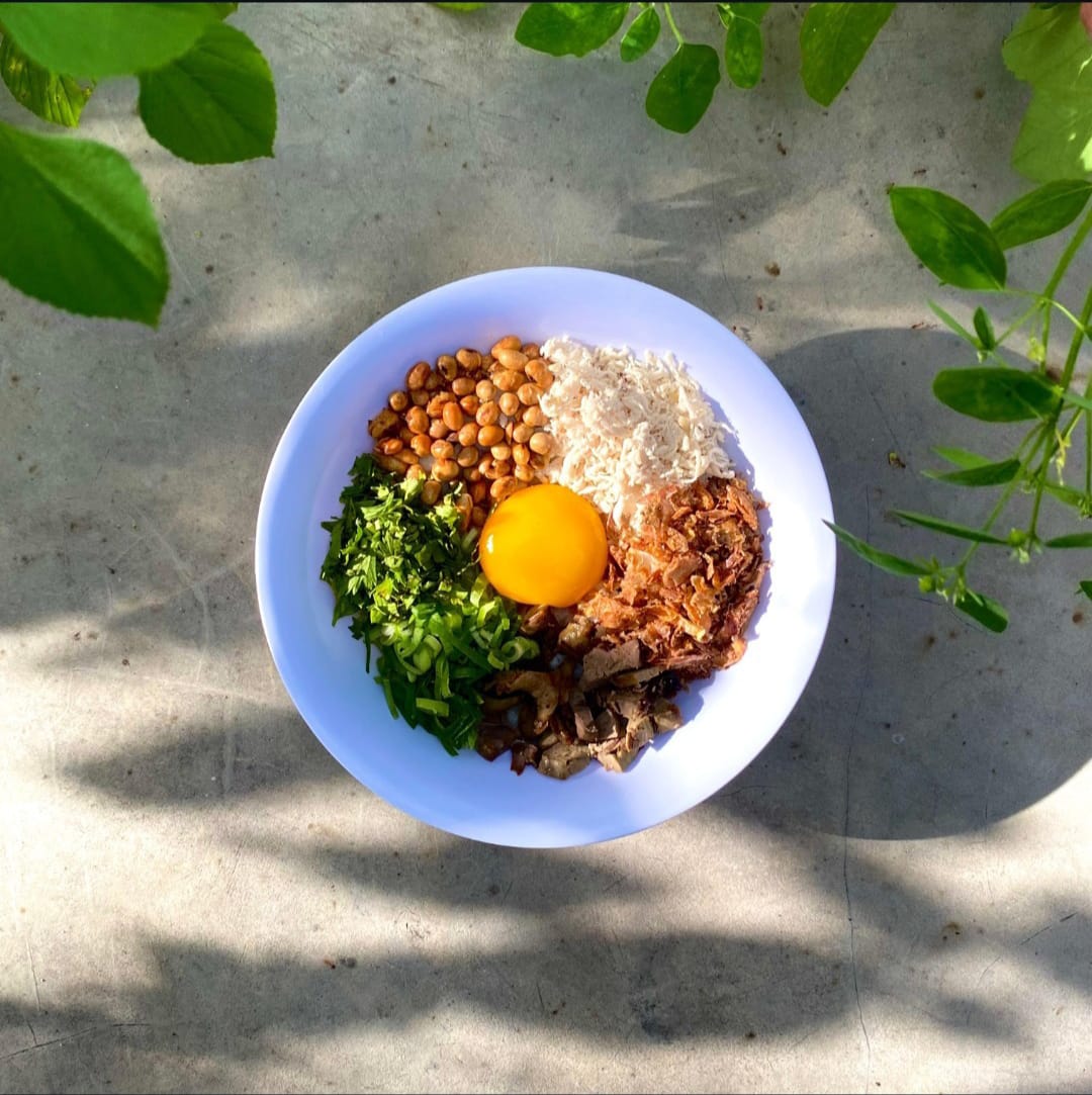 Seporsi bubur hayam yang hangat dan menggugah selera.
