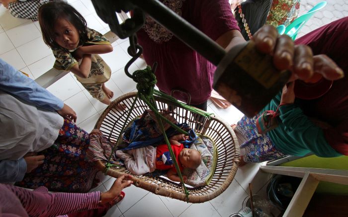 BERI PELAYANAN: Petugas menimbang berat badan anak dalam kegiatan Posyandu (Pos Pelayanan Terpadu) di Kampung Prawirodirjan, Prawirodirjan, Gondomanan, Kota Jogja.