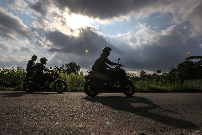 PERALIHAN MUSIM: Pengendara motor melintas berlatar langit dengan gumpalan awan mendung di kawasan Wedomartani, Ngemplak, Sleman Rabu (9/10/2024).