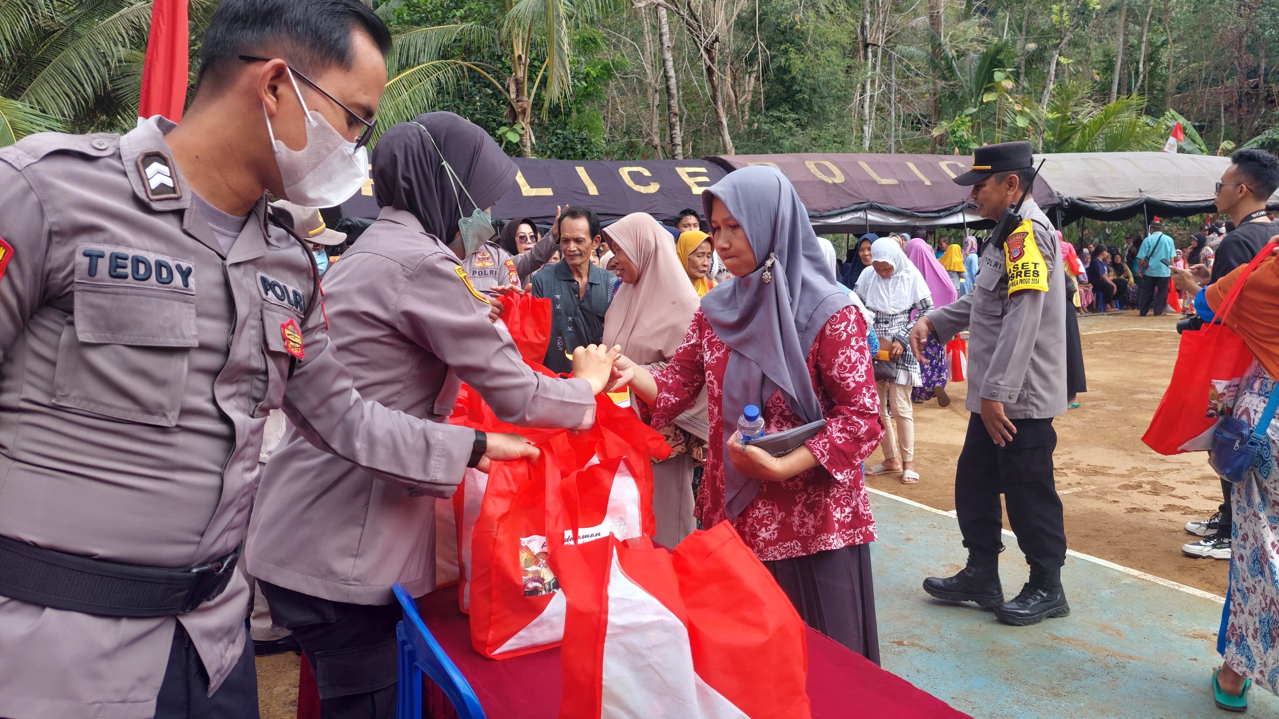 BAKTI: Anggota Polres Kulon Progo dan Polda DIJ memberikan paket sembako.&nbsp;