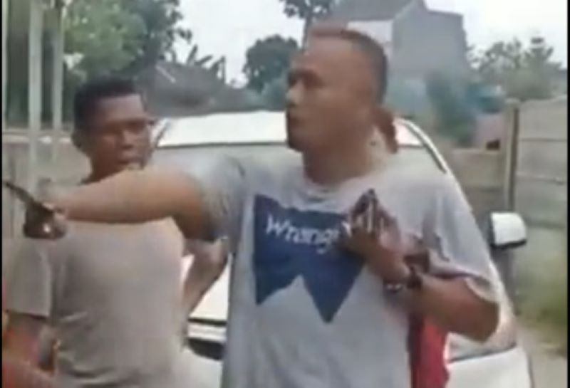 Terlihat seorang pria yang membawa golok.