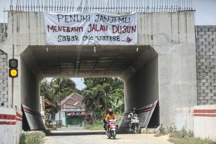 Spanduk protes warga terpasang di konstruksi trowongan jalan tol Jogja-bawen kawasan Pundong, Tirtoadi, Mlati, Sleman, Selasa (15/10/2024).