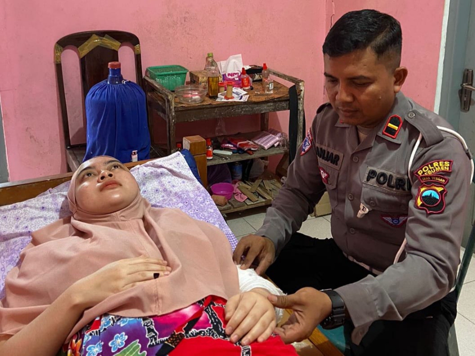 PELAYANAN MASYARAKAT: Personel Polres Kebumen Ipda Lanjar Pamuji sedang melayani pasien yang mengalami keluhan pada bagian tulang dan sendi.