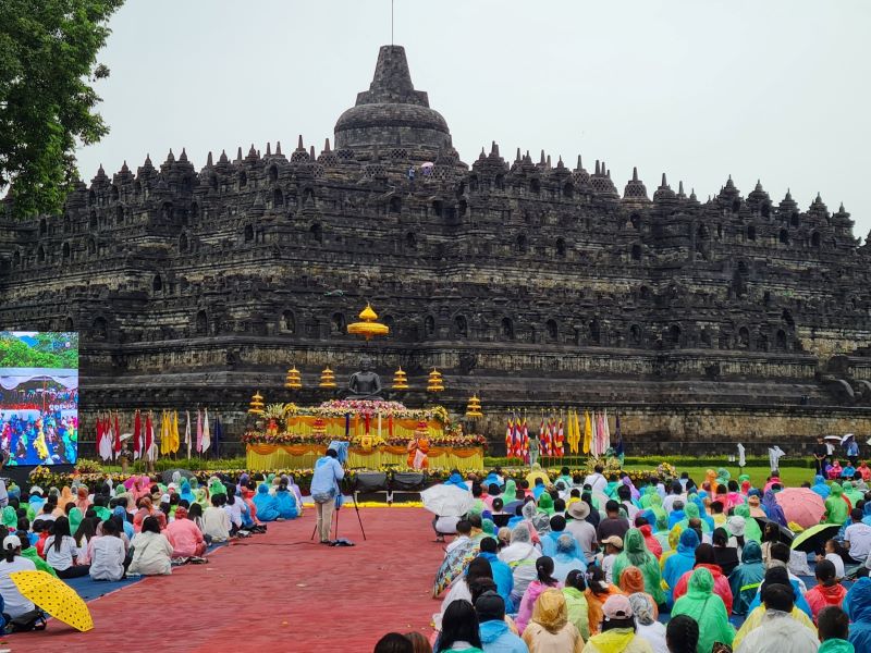 KHIDMAT: Para umat Buddha menggelar Magha Puja 2023 di Candi Borobudur. Meski hujan, mereka tetep berdoa lengkap dengan payung dan jas hujan.