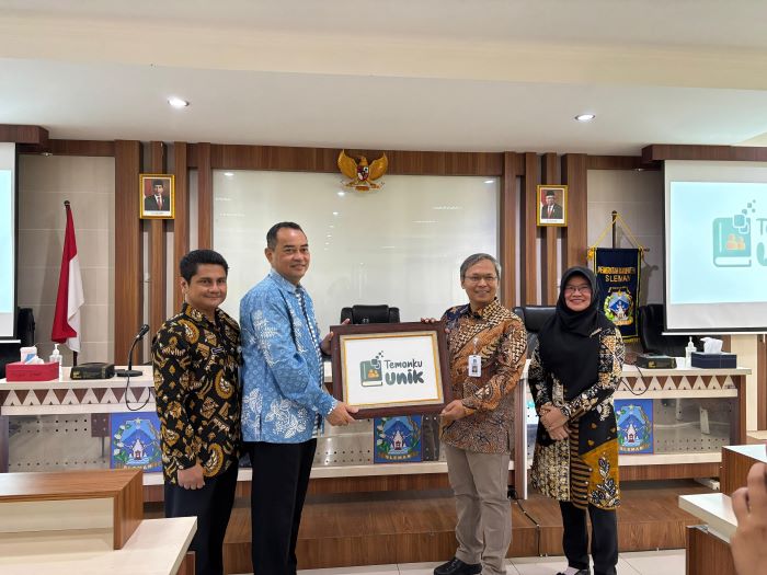Plt Kepala Dinas Kominfo Sleman Eka Suryo Prihantoro (dua dari kiri) secara simbolis menyerahkan plakat Temanku Unik kepada Pjs Bupati Sleman Kusno Wibowo saat peluncuran pencatat buku tamu elektronik