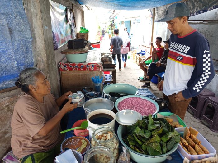 LAYANI PEMBELI: Mak Cowek tengah melayani pembeli yang datang dari berbagai daerah. Mengingat dawet ini cukup legend.