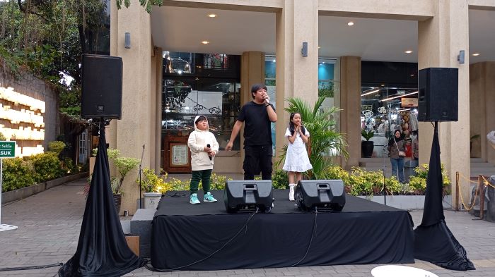UPAYA LEWAT MUSIK: Vokalis Goliath Ary Irawan bersama kedua buah hatinya saat bernyanyi di Teras Malioboro (TM) 1, Jumat (18/10/2024) sore.