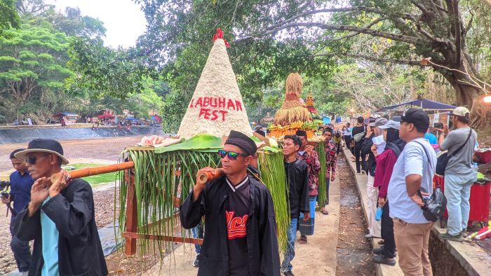 KOLABORASI: Masyarakat memikul gunungan bertuliskan Labuhan Fest Kalurahan Girisuko, Panggang, Gunungkidul. Acara itu juga menjadi ajang promosi UMKM desa preneur binaan Dinas Koperasi dan UKM DIY.
