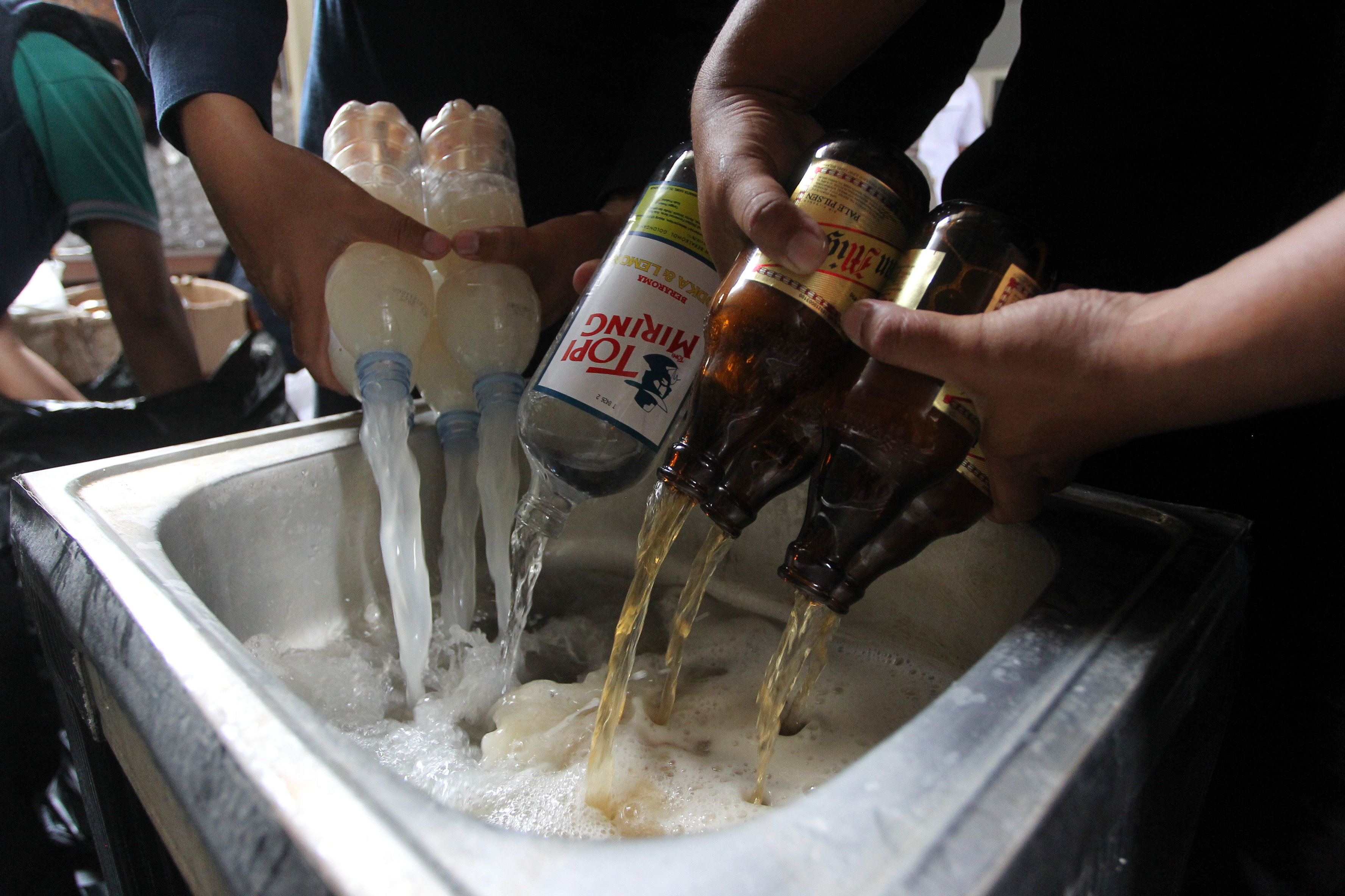 PICU KEJAHATAN: Petugas memusnahkan barang bukti minuman keras hasil operasi razia di Mapolresta Jogja, kemarin (22/10). Pemusnahan dila