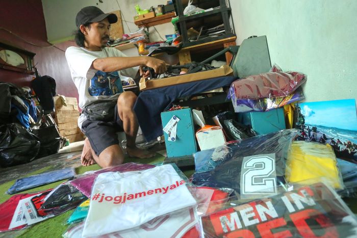 MOMENTUM: Penyablon menyelesaikan kaus pesanan kaus paslon pilkada di rumah produksi kawasan Ngestiharjo, Kasihan, Bantul Rabu (23/10/2024).