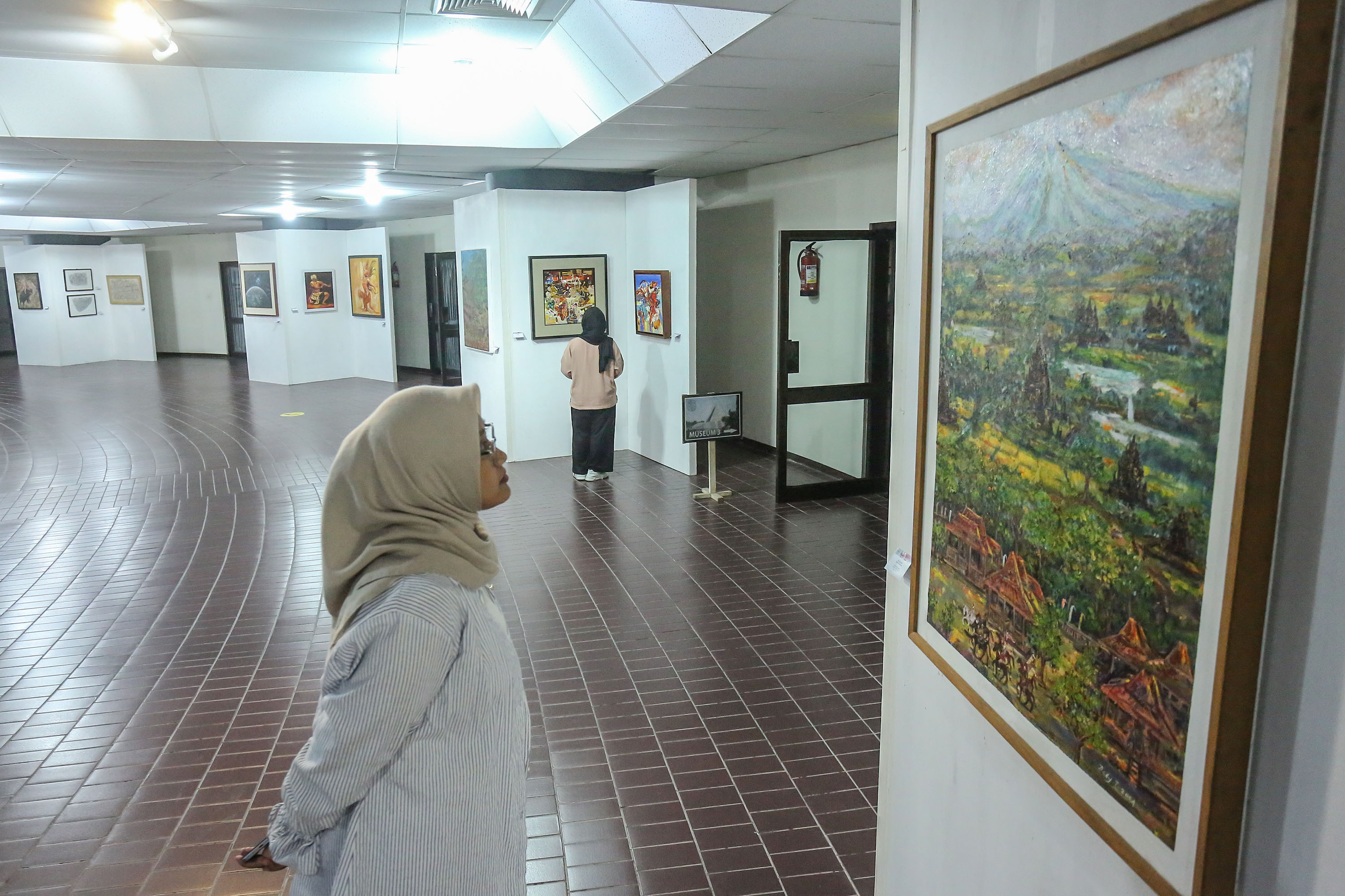 Pengunjung menyaksikan karya lukisan saat pameran seni rupa "Young Spirit" di Monumen Jogja kembali, Sariharjo, Ngaglik, Sleman, Kamis (24/10). Pameran yang diikuti sebanyak 18 seniman itu digelar oleh Komunitas Perupa Sleman
