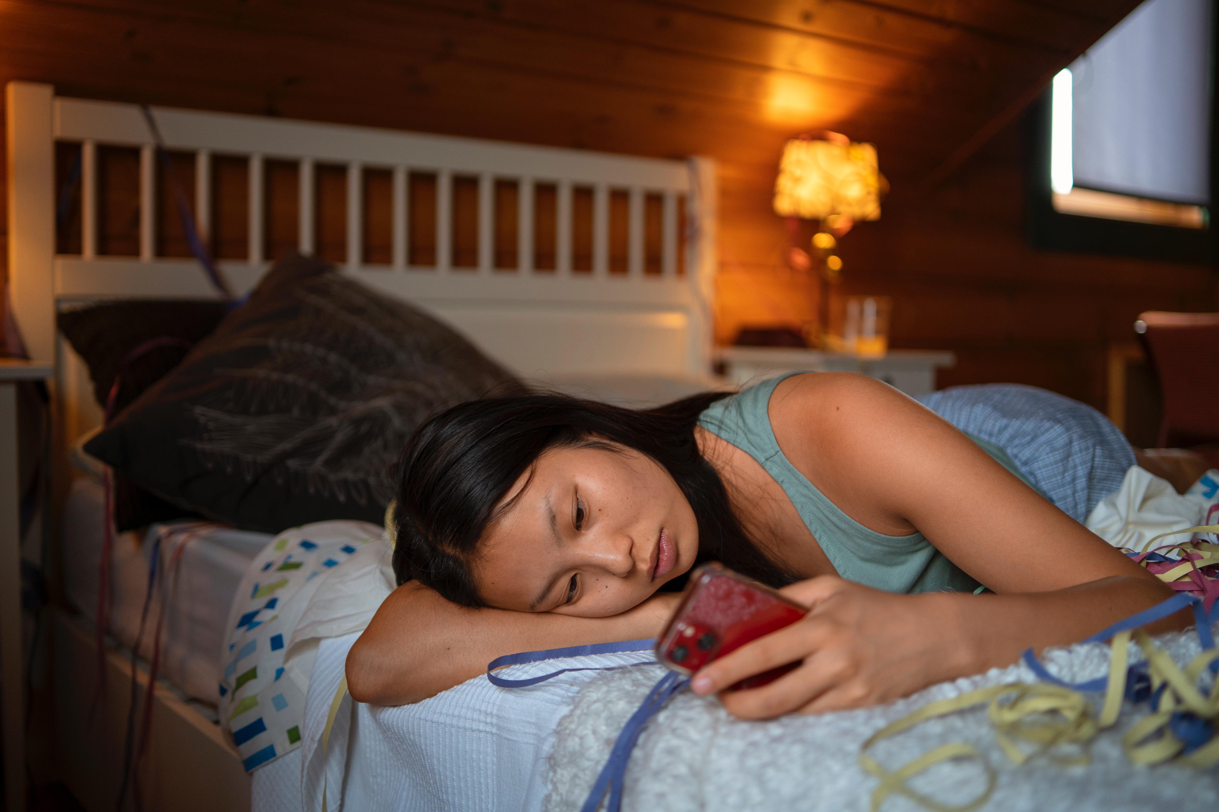 seorang wanita bermain gadget hingga larut malam dan begadang.&nbsp;