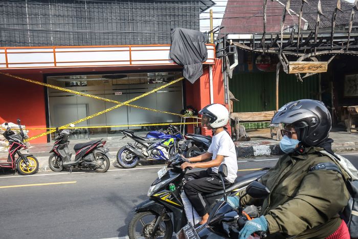 Kendaraan roda dua melintasi gerai penjual miras yang ditutup dengan garis polisi di kawasan Brontokusuman, Mergangsan, Jogja, Kamis (31/10/2024).