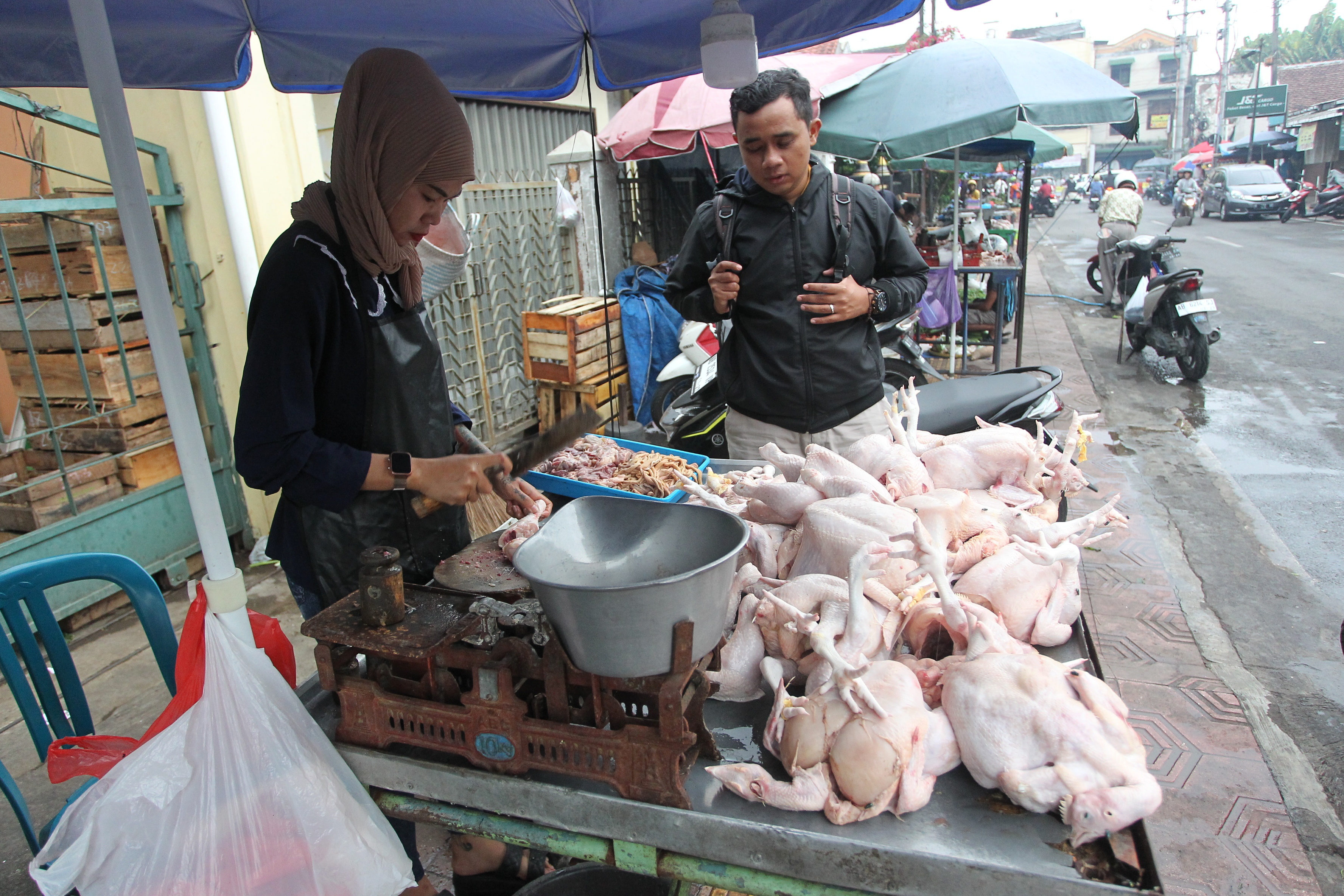ILUSTRASI: Pedagang daging ayam melayani permintaan pembeli di Jalan Poncowinatan, Kota Jogja, beberapa waktu lalu.