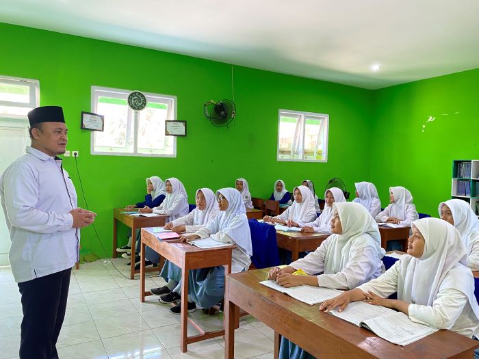 FOKUS: Andri Efriadi saat mengajar siswa di Pondok Pesantren (Ponpes) Darul Mushlihin Jumat (1/11/2024). Dia berhasil mendirikan sekolah setara SMA gratis di kawasan selat
