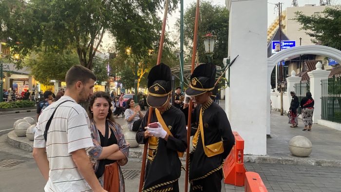 BUTUH INFORMASI: Dua orang prajurit Bregada Suryatmaja menjawab pertanyaan dari dua orang turis asing yang tengah berkunjung di kawasan Malioboro, Minggu (3/11/2024).