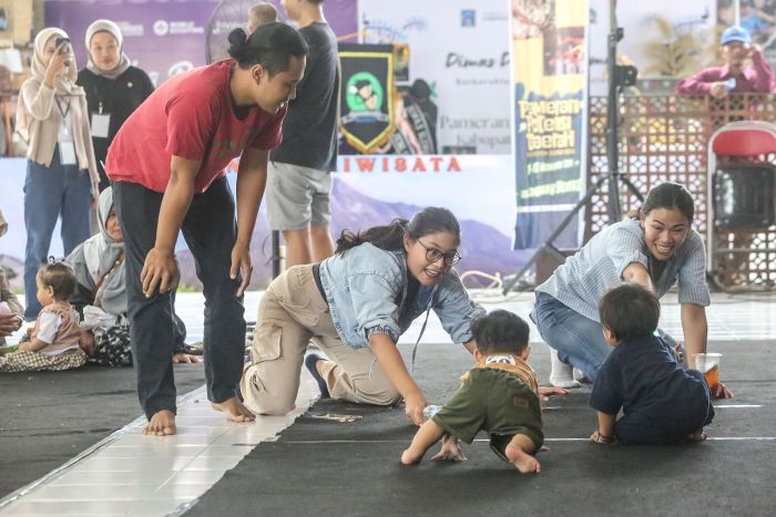ANTUSIAS: Para orang tua berusaha memanggil bayi mereka saat adu cepat lomba bayi merangkak di Gedung Serba Guna, Tridadi, Sleman Jumat (8/11/2024).